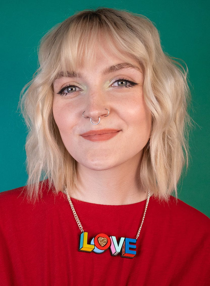 Multi-coloured acrylic LOVE Necklace worn on a red top
