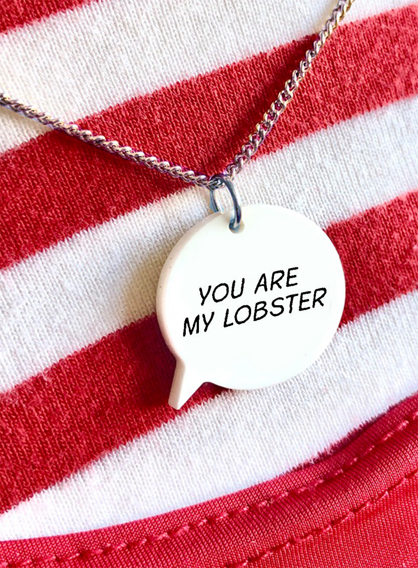 Personalised speech bubble necklace with a pendant that says 'At tea time everybody agrees' on a white background.