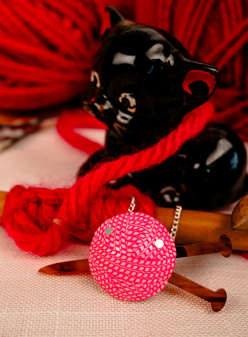 Detail of the inking on the pink ball of wool necklace