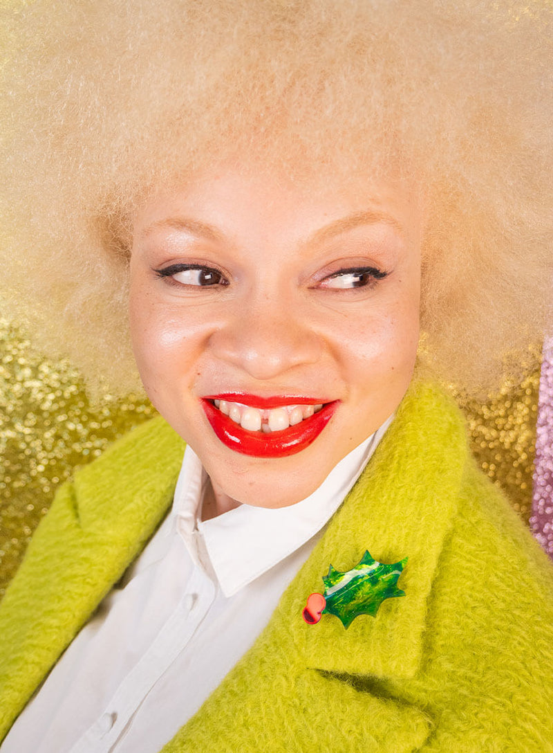 Christmas Holly Coat Brooch made from glitter-flecked acrylic worn by a model