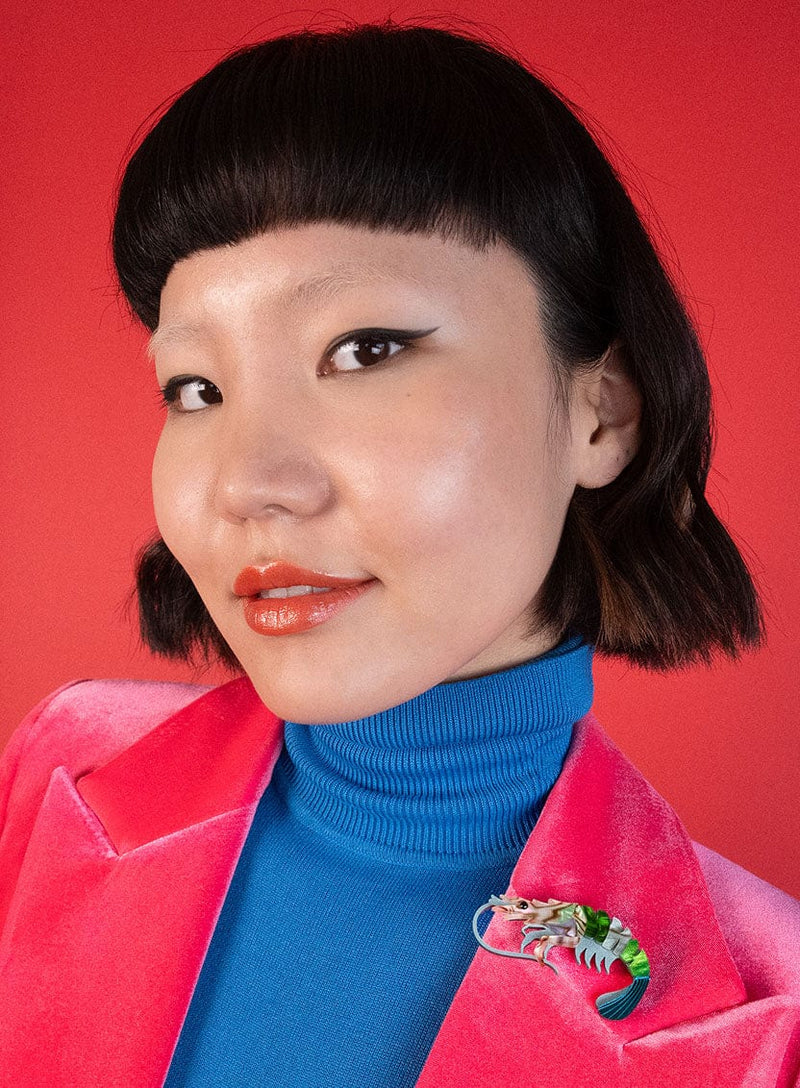 Green Pearly Prawn Brooch pinned on a red lapel